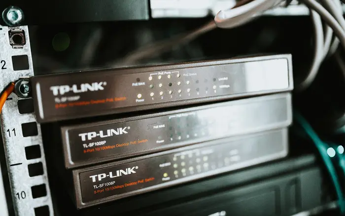 Network switches arranged in a server rack with visible LED lights indicating connection status and power levels